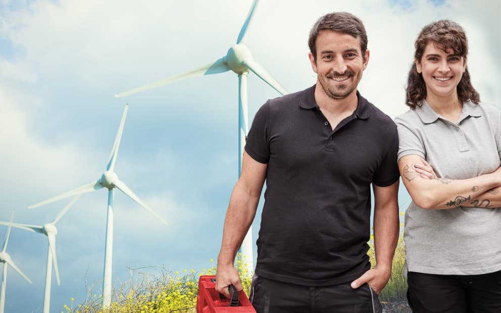 Des installateurs devant des éoliennes