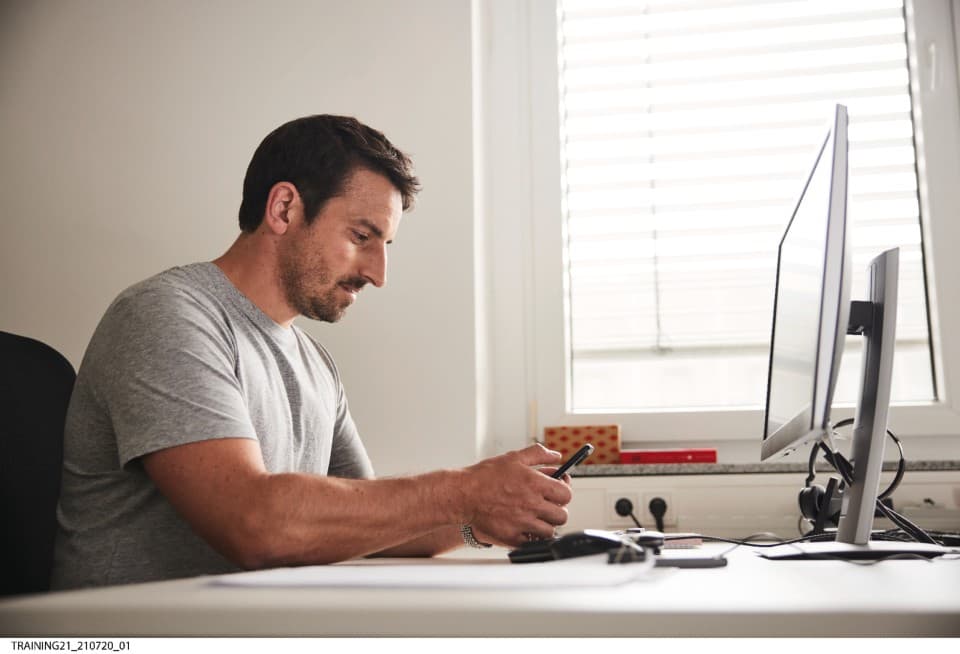 Visuel installateur derrière son ordinateur connecté à la plateforme e-Shop